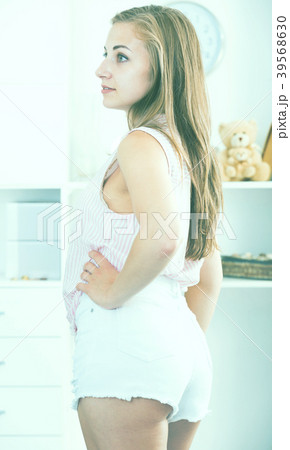 Smiling girl in half-turn at home interior Smiling girl in half-turn at home interior 39568630