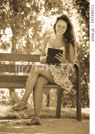Girl on bench in park with ereader Girl on bench in park with ereader 39568911