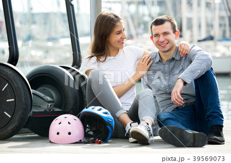 Couple sitting near segways at sea front 39569073