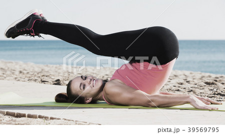 Woman doing yoga at beach 39569795