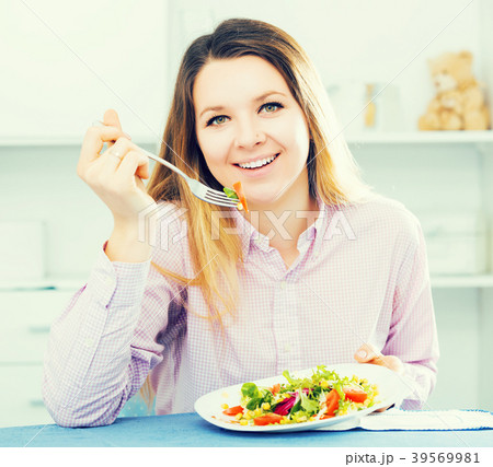 Woman tasting fresh green salad Woman tasting fresh green salad 39569981