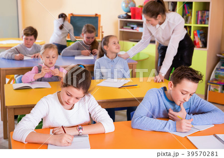 Portrait of young teacher woman at lesson with diligent school kids 39570281