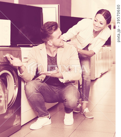 Positive customers looking at laundry machine Positive customers looking at laundry machine 39570680