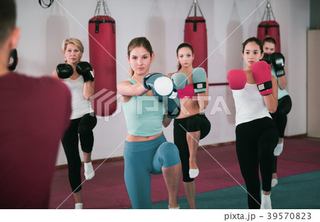 women are boxing and doing kick with coach 39570823