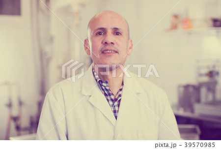 Middle aged worker standing near the table Middle aged worker standing near the table 39570985