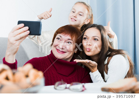 Senior woman taking selfie with family Senior woman taking selfie with family 39571097