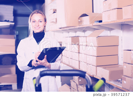 Female worker transporting cart cardboard cases 39571237