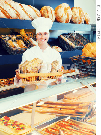 Woman offering bread in bakery Woman offering bread in bakery 39571413