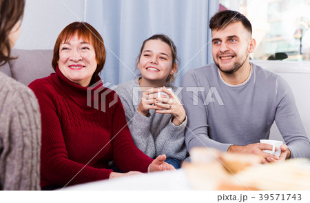 Cheerful family meeting female guest at home 39571743