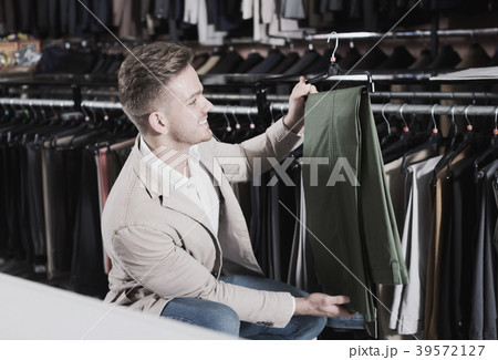 Ordinary man choosing new trousers Ordinary man choosing new trousers 39572127