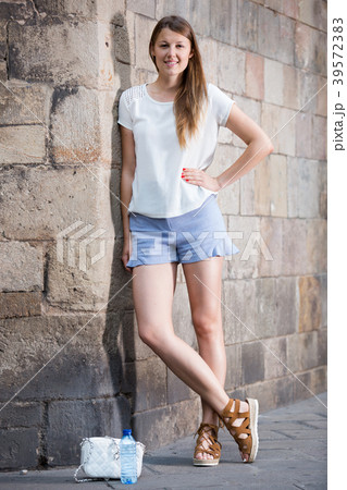 Young woman standing near old stone wall Young woman standing near old stone wall 39572383