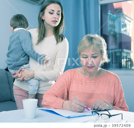 Aged woman is quarreling with her daughter for documents Aged woman is quarreling with her daughter for documents 39572409