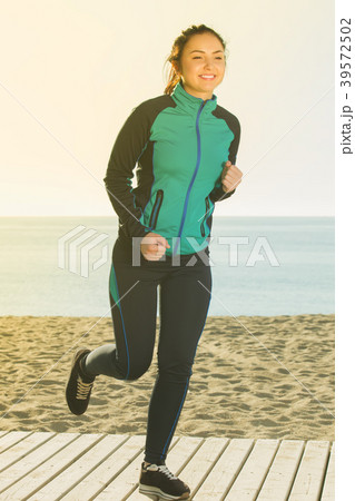 Charming woman running on beach 39572502