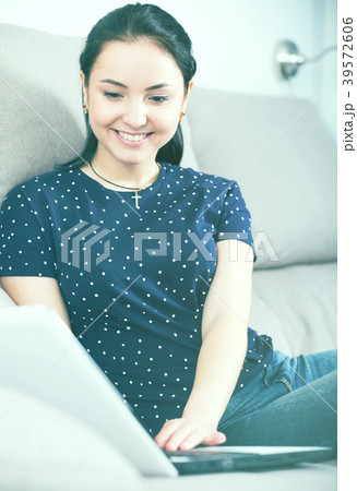 Woman using laptop on sofa Woman using laptop on sofa 39572606