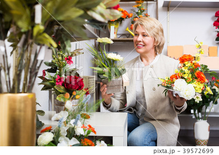 Woman selecting flowers in store 39572699