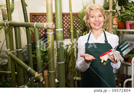 Florist in apron holding tools 39572804