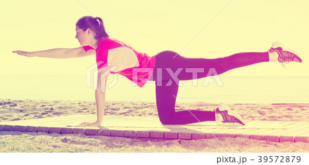 Girl practicing yoga poses on beach Girl practicing yoga poses on beach 39572879