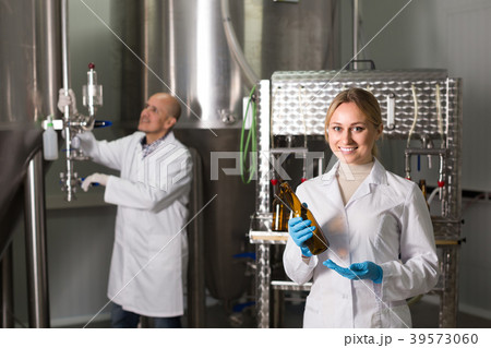 Two brewery workers on beer factory. Two brewery workers on beer factory. 39573060