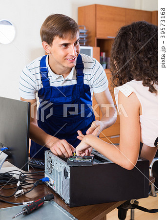 Girl and repairman fixing computer . 39573168