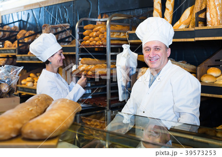 working bakers with fresh bread in bakery working bakers with fresh bread in bakery 39573253