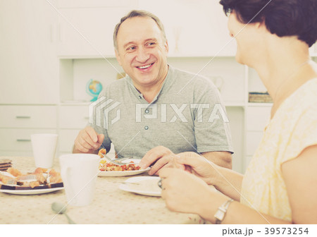 Mature man eating lunch and listening to woman 39573254