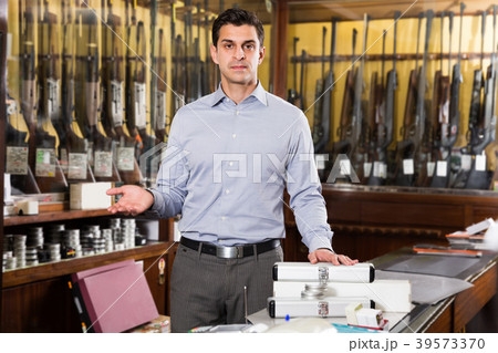 Male seller offering necessary hunting equipments 39573370