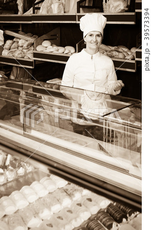 Portrait of baker with sweet cakes in local confectionery Portrait of baker with sweet cakes in local confectionery 39573394