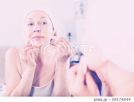 Woman doing body hair removal 39574044