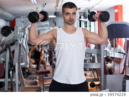 Man exercising with dumbbells in gym 39574229