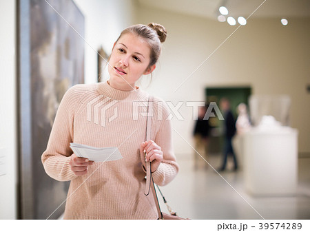 Laughing girl holding guide book in museum Laughing girl holding guide book in museum 39574289