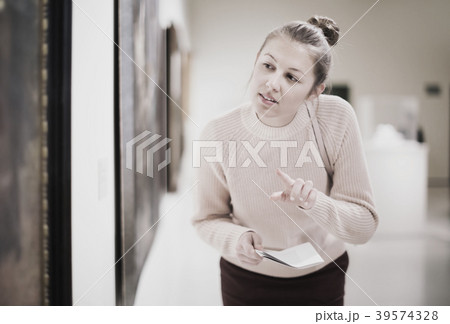 Woman with guide looking at pictures in museum Woman with guide looking at pictures in museum 39574328