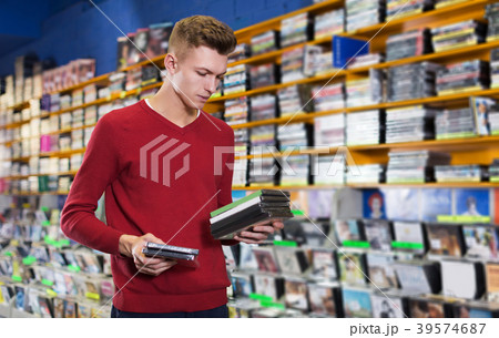 guy looking on box of DVD movie guy looking on box of DVD movie 39574687