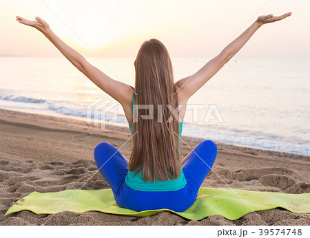 Cheerful sport female is posing playfully on beach in her free time Cheerful sport female is posing playfully on beach in her free time 39574748