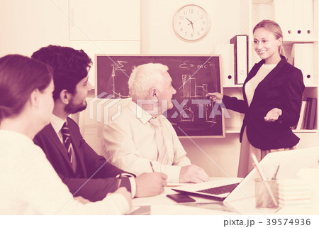 Manager female is reading financial report to colleagues on meeting Manager female is reading financial report to colleagues on meeting 39574936
