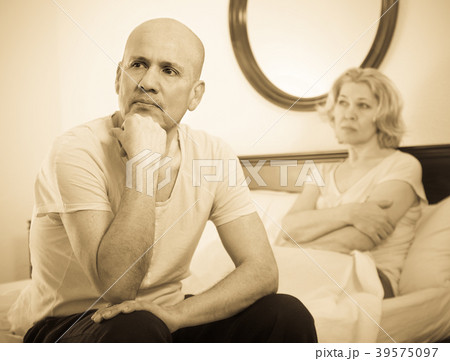 Mature couple sorting out relationships in bed. Mature couple sorting out relationships in bed. 39575097
