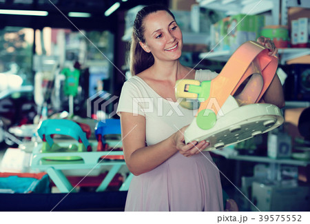Young pretty pregnant woman shopping in store Young pretty pregnant woman shopping in store 39575552