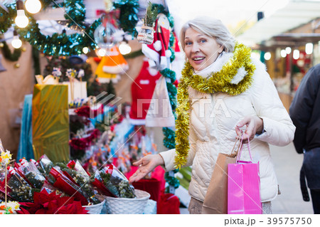 Female buying decoration and brush of tree at Christmas Fair 39575750