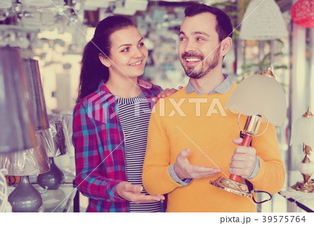 Smiling man and girl in lighter shop choose desk lamp 39575764