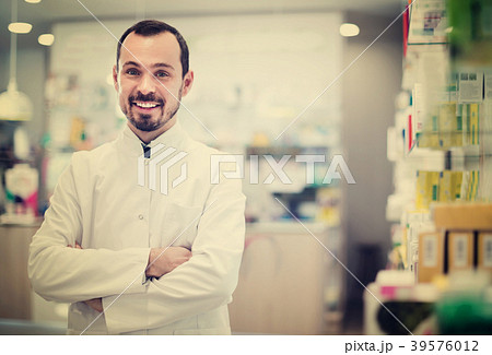 Male pharmacist demonstrating assortment of drugs 39576012