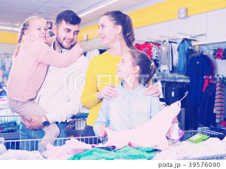 family with two girls choosing new clothes 39576090