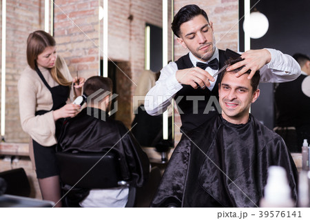 Hairdresser man doing styling of guy Hairdresser man doing styling of guy 39576141
