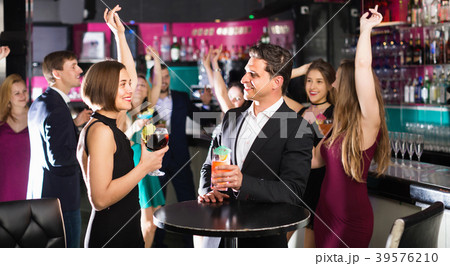 Colleagues dancing on corporate party with cocktails in hands 39576210
