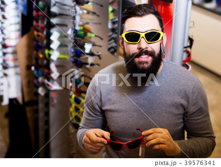 Guy deciding on new sunglasses Guy deciding on new sunglasses 39576341