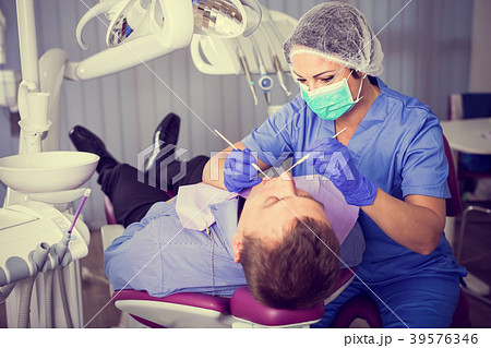 adult dentist checking teeth of patient adult dentist checking teeth of patient 39576346