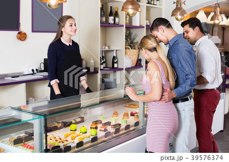 Glad female helping customers to choose sweets 39576374