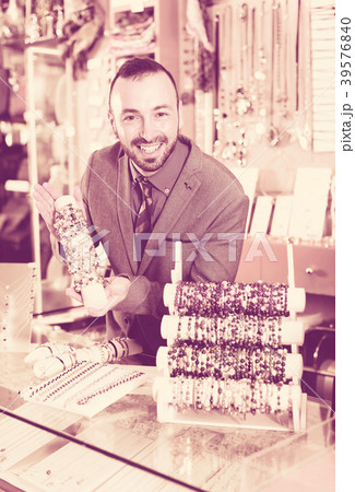 seller showing bracelets in the jewelry shop 39576840