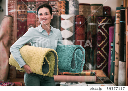 Cheerful woman customer shopping carpet in store Cheerful woman customer shopping carpet in store 39577117