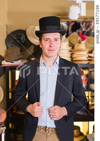 adult male shopping in botique and try on cylinder hat 39577196