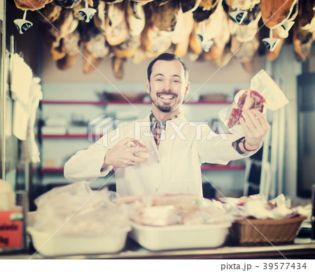 Seller offering displayed sorts of meat 39577434
