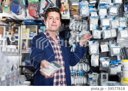 Young male seller showing switches for light 39577618